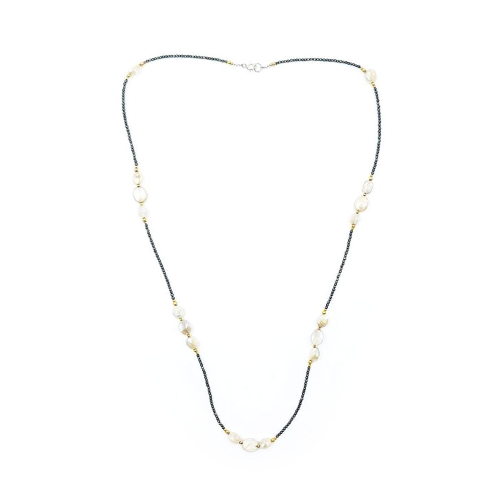 Long necklace featuring tiny dark pyrite beads, peach moonstone oval beads, small gold-tone accents, and a silver-tone clasp, displayed on a white background.