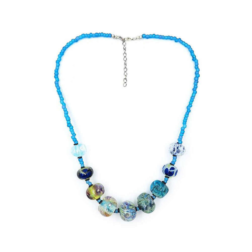 Handmade beaded necklace featuring bright turquoise seed beads, assorted blue and multicolored glass accent beads, and a silver-tone clasp with extender chain on a white background.