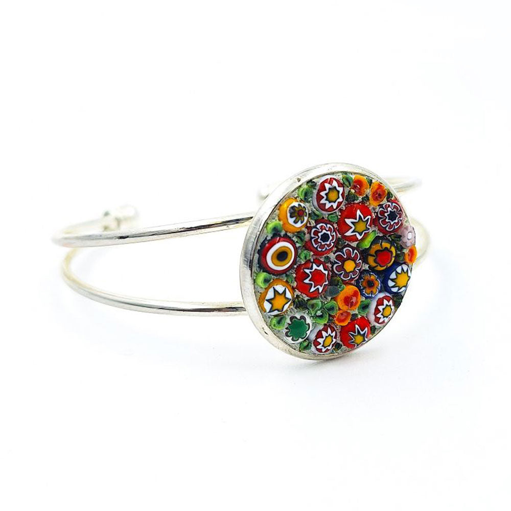 Silver-tone open cuff bracelet featuring a round mosaic glass face with red, white, yellow, orange, and green floral details on a white background.