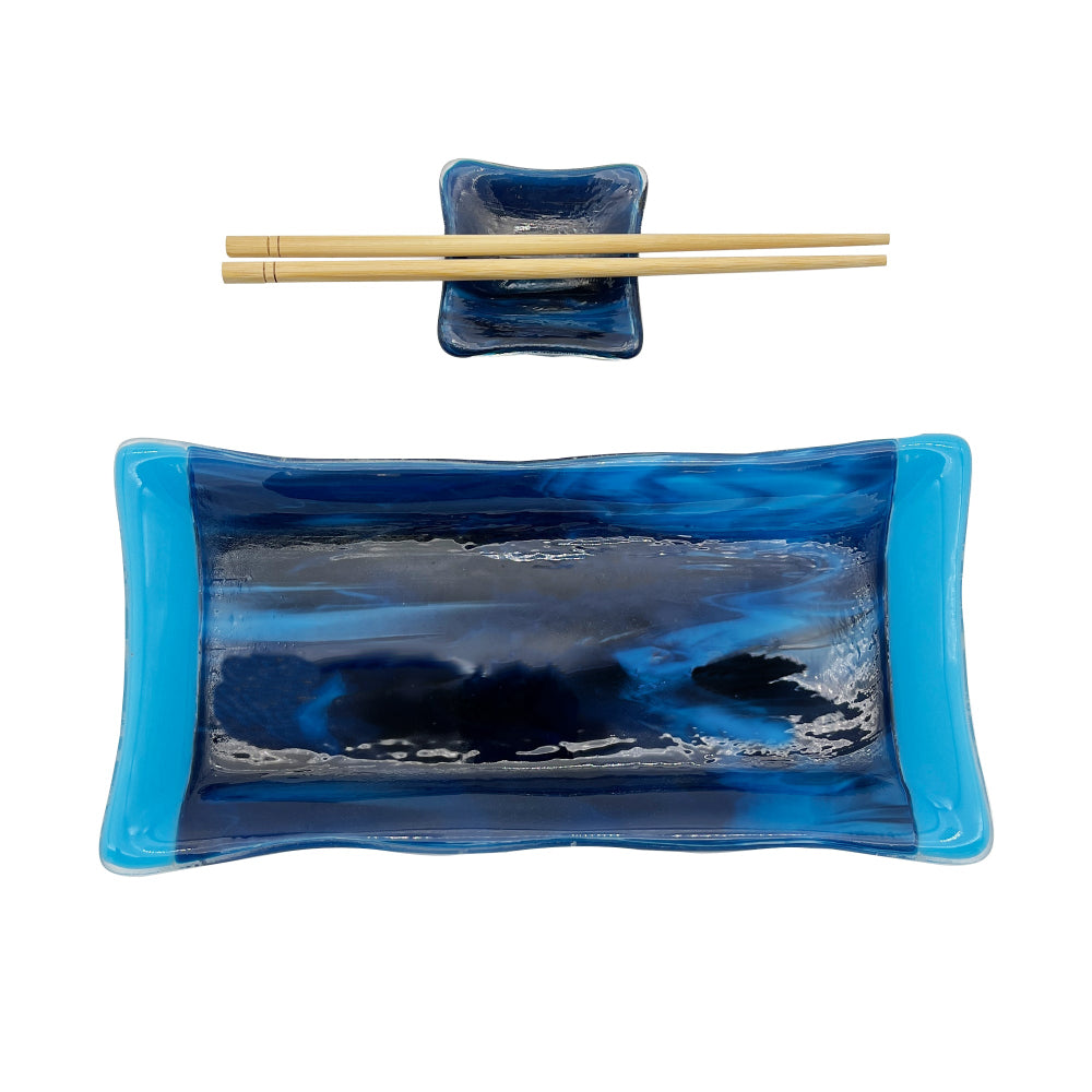 Handmade green glass sushi set featuring a rectangular serving plate, matching square sauce dish, and a pair of light wood chopsticks on a white background.