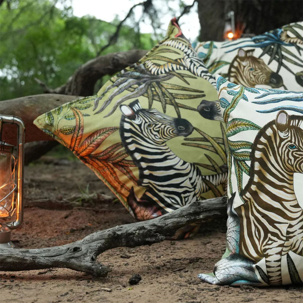Thanda Stripe pillows styled outdoors with zebra print, botanical details, and lantern.