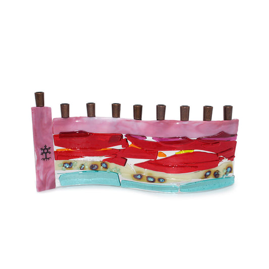 Handmade fused glass menorah featuring layered pink, red, orange, cream, and aqua glass with decorative blue accents and nine dark metal candle holders on a white background.