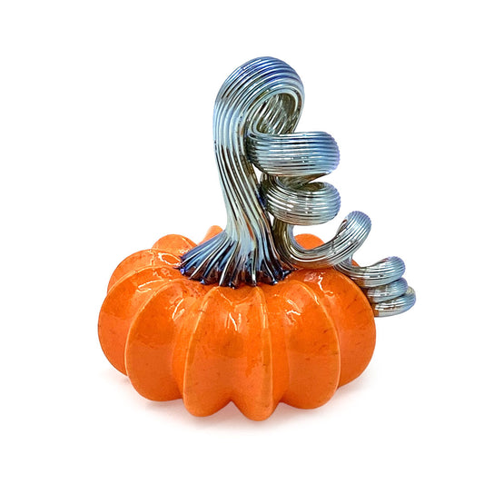 Orange decorative glass pumpkin with a tall, curling silver-blue ribbed glass stem, displayed on a white background.