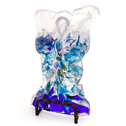 Angled view of a handmade translucent glass bust sculpture featuring flowing aqua, turquoise, cobalt blue, purple, and clear glass details, displayed on a dark metal stand against a white background.
