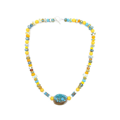 Full view of a yellow and turquoise glass bead necklace featuring alternating round and patterned beads with a large oval turquoise and brown focal bead at the center on a white background.