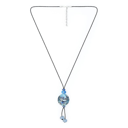 Full view of a long black cord necklace with a round blue glass pendant, dangling pale blue beads, and an adjustable silver-tone chain.