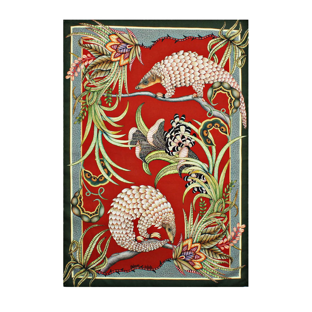 Rectangular Ardmore tea towel featuring three illustrated pangolins, tropical flowers, curling foliage, and a large patterned butterfly on a vivid red background.