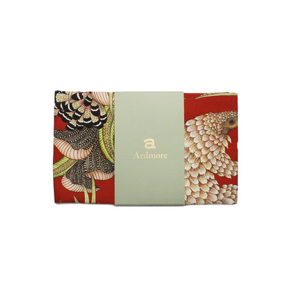 Folded Ardmore pangolin-print tea towel wrapped with a pale green branded paper band.