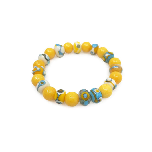 Yellow glass bead bracelet featuring glossy round beads with blue, white, and turquoise swirl accents, arranged in a circular design on a white background.
