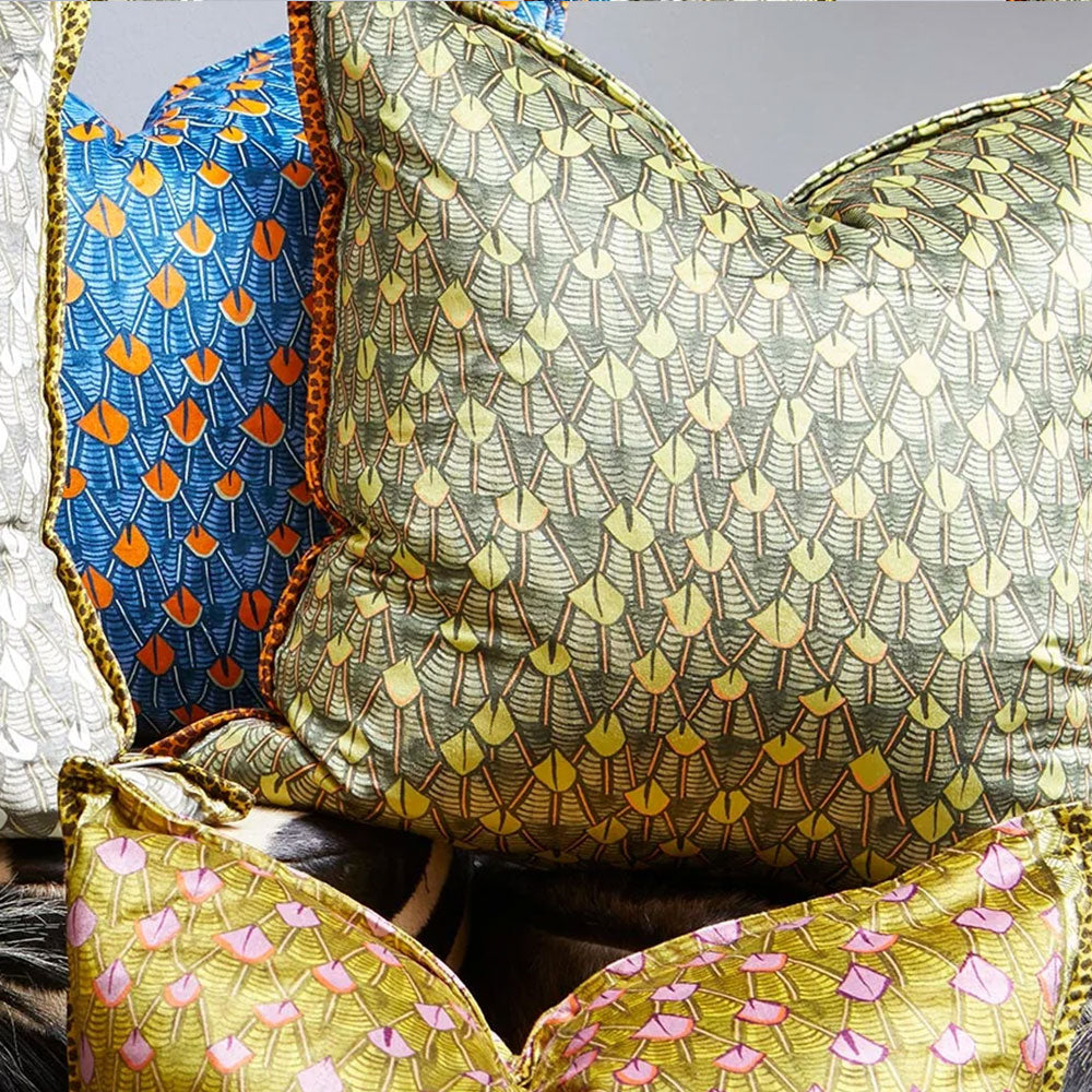 The Feather Pillow arranged alongside matching feather-patterned pillows in blue, yellow, and pink colorways.
