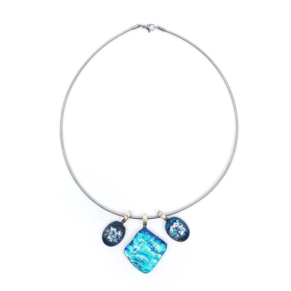 Full view of a stainless steel chain necklace featuring three blue dichroic glass charms with sterling silver pinch bails, including a square center pendant and two smaller oval side charms.