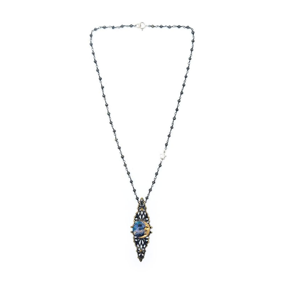 Full view of an ornate necklace featuring a dark beaded chain and an elongated antique gold-tone and black filigree pendant with painted blue metal in the center.
