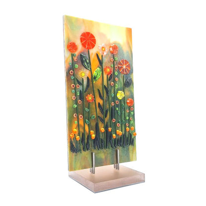 Side view of aventurine green and orange fused glass tulip panel with raised floral details on an acrylic stand.