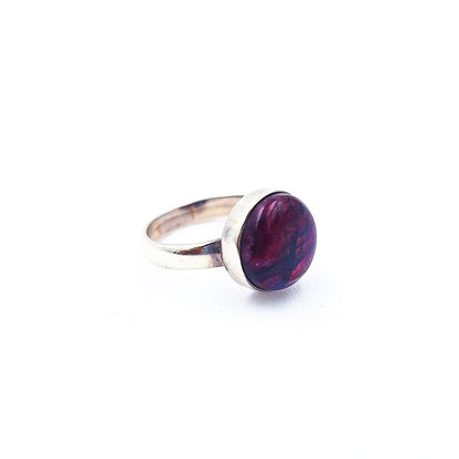 Silver-tone ring featuring a round purple cabochon with marbled burgundy and violet tones, displayed on a white background.