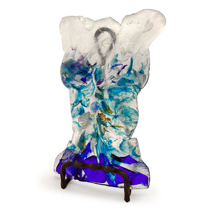 Angled view of a handmade translucent glass bust sculpture featuring flowing aqua, turquoise, cobalt blue, purple, and clear glass details, displayed on a dark metal stand against a white background.
