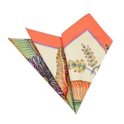 Folded Thanda Bloom napkins showing a coral border, botanical print, and floral details.
