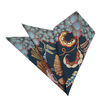 Folded midnight Thanda Nest napkins showing African masked weaver birds, seed pods, and patterned foliage.