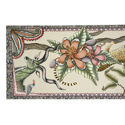 Close-up of an Ardmore table runner decorated with antelope, birds, tropical flowers, foliage, and richly patterned borders.