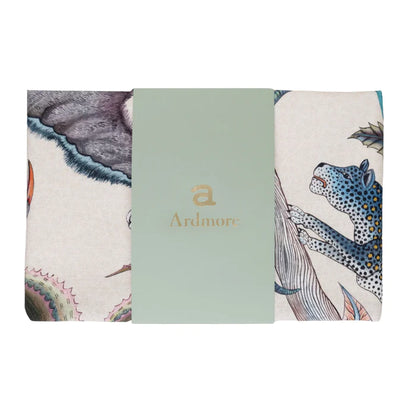 Folded Ardmore tea towel featuring wildlife and botanical illustrations, wrapped with a pale green branded paper band.