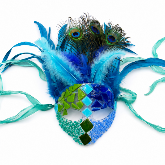 Handmade masquerade mask decorated with turquoise, cobalt blue, lime green, and aqua glass accents, surrounded by bright blue feathers, peacock feathers, and flowing teal ribbon ties on a white background.