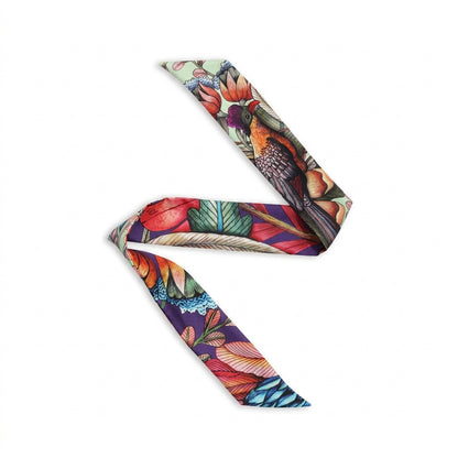 Phinda Pride Paradise Silk Twill featuring a vibrant botanical and wildlife-inspired print with tropical flowers, layered leaves, feathers, and rich shades of red, orange, green, teal, purple, and cream.