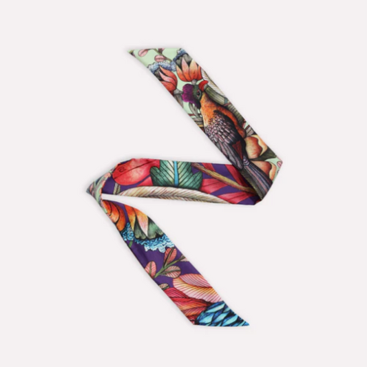 Phinda Pride Paradise Silk Twill featuring a vibrant botanical and wildlife-inspired print with tropical flowers, layered leaves, feathers, and rich shades of red, orange, green, teal, purple, and cream.