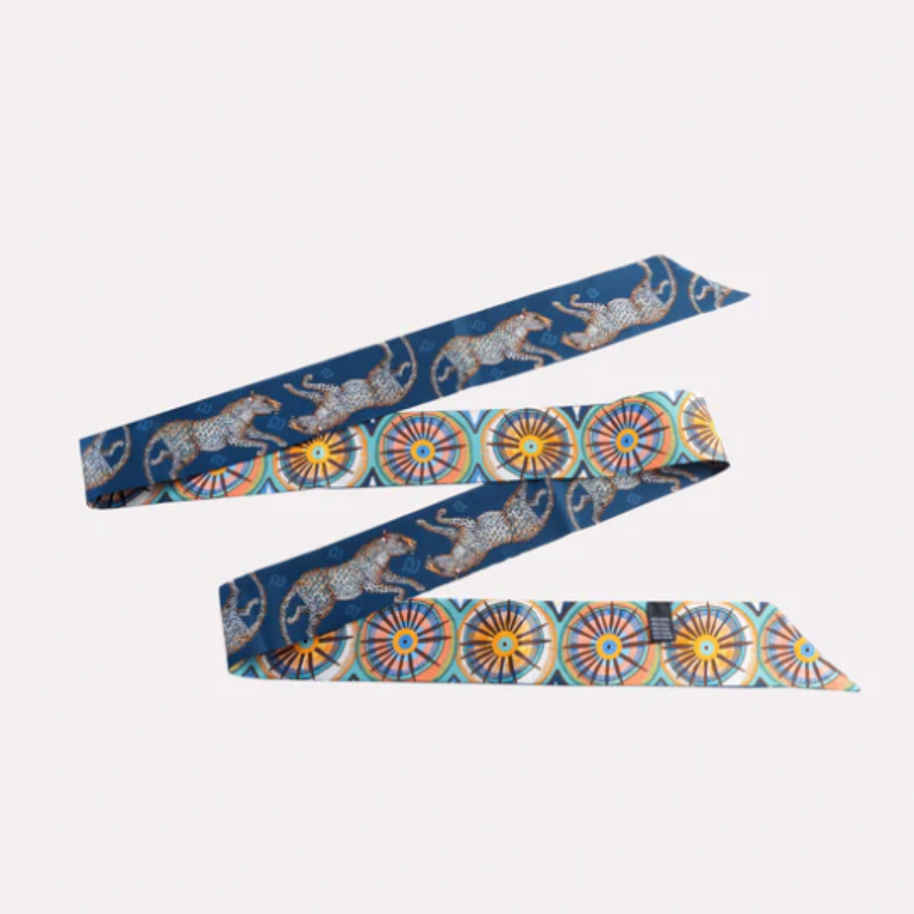 Cat Walk Tanzanite Silk Twill by Ardmore Design featuring a deep tanzanite blue background with illustrated big cats, botanical details, and colorful circular geometric borders in orange, turquoise, cream, and gold tones.