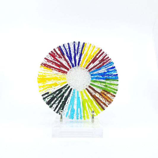 Small rainbow fused glass circle sculpture displayed on a clear acrylic stand.