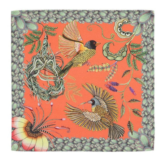 Coral Thanda Nest napkin with African masked weaver birds, woven nest, flowers, foliage, and patterned border.