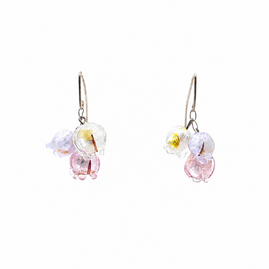 Pair of floating silver-tone drop earrings featuring clusters of translucent glass flowers in clear, pale lavender, and soft pink on a white background.