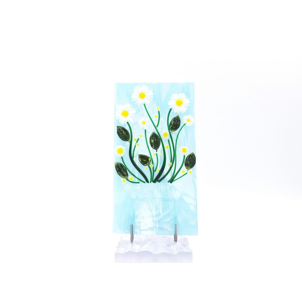 Front view of the White Daisies Panel featuring white flowers with yellow centers, green stems, and dark green leaves on a pale blue glass background with a white textured base.