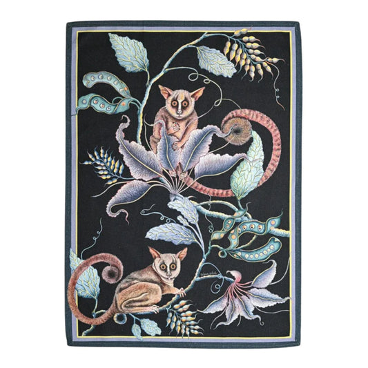 Bush Baby Tea Towel featuring two illustrated bush babies surrounded by curling vines, seed pods, flowers, and layered foliage on a deep black background with a subtle border. 