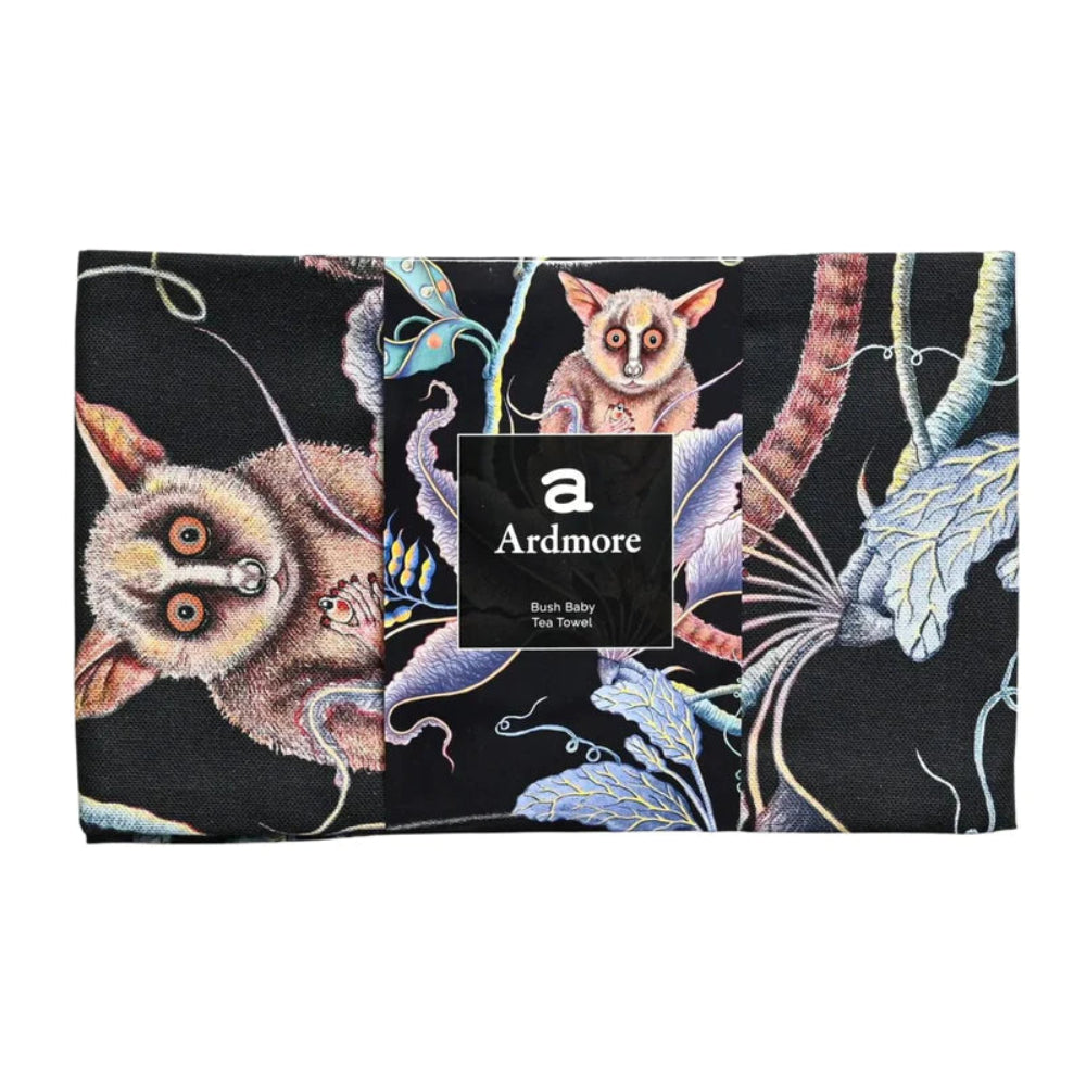Folded Bush Baby Tea Towel by Ardmore wrapped with a black branded paper band, showing close-up sections of the bush baby and botanical print. 