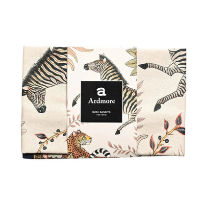 Folded Bush Bandits Tea Towel by Ardmore wrapped with a black branded paper band, showing sections of the zebra, leopard, and botanical print.