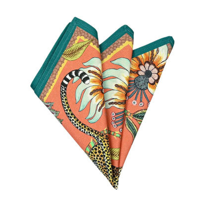 Folded Leopard Napkins in coral showing leopard print, passion flower details, and teal edging.