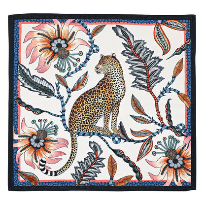 Square cloth napkin featuring a seated leopard surrounded by oversized coral flowers, dark foliage, and colorful botanical details with a navy border.
