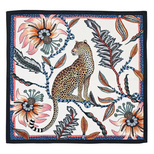 Square cloth napkin featuring a seated leopard surrounded by oversized coral flowers, dark foliage, and colorful botanical details with a navy border.