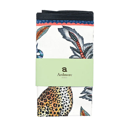 Folded Ardmore cloth napkin featuring a leopard-and-botanical print, wrapped with a pale green branded paper band.