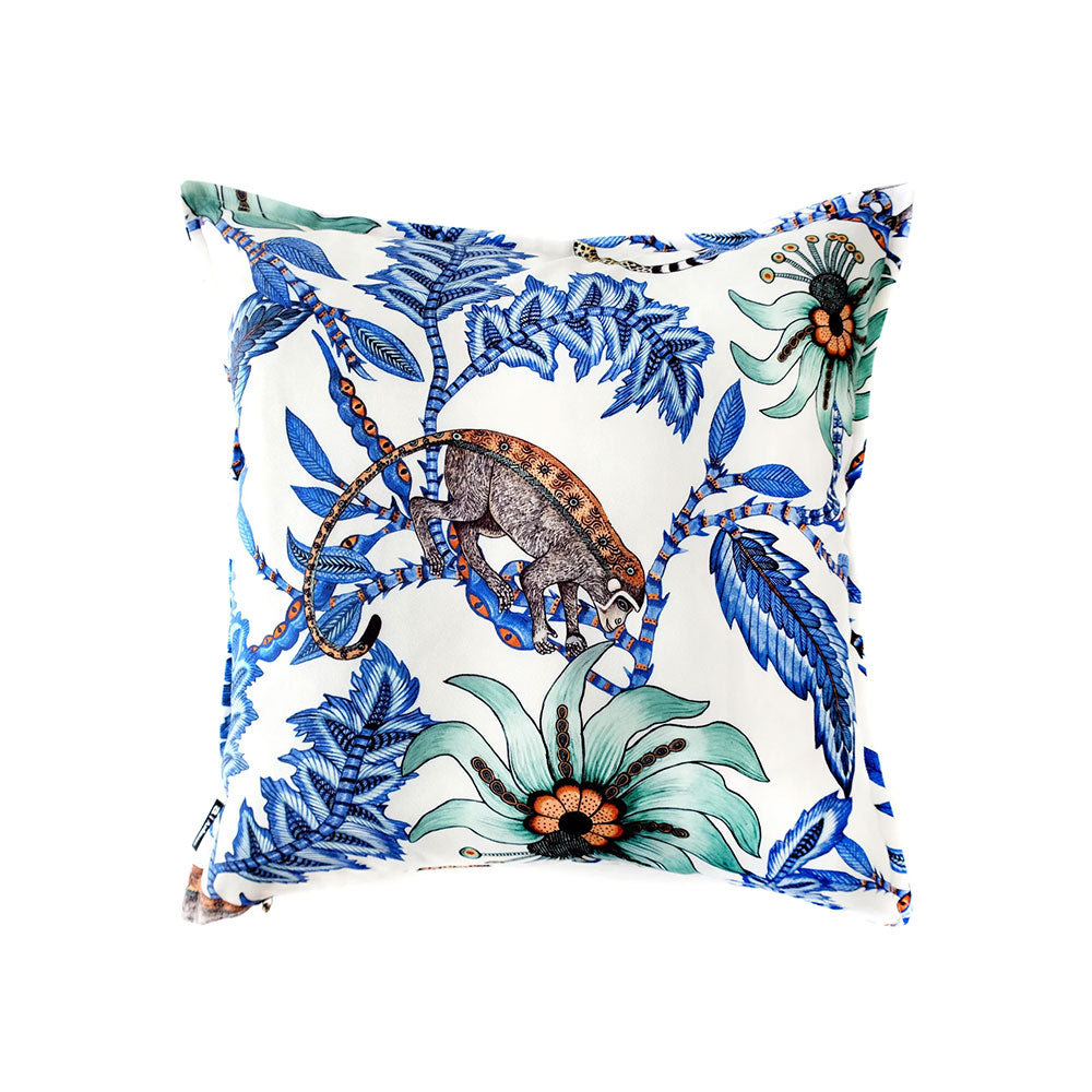 Reverse view of the blue Monkey Bean Pillow displaying blue leaves, pale green flowers, and a detailed illustration of a monkey perched on a branch. 