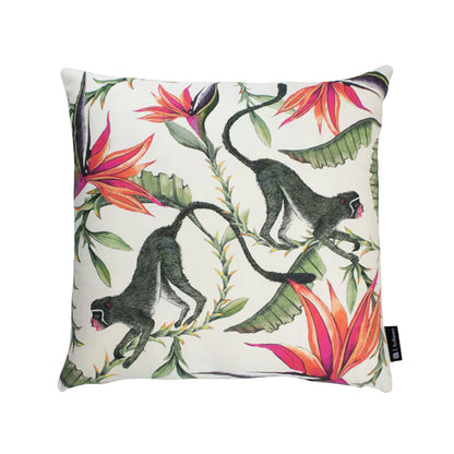 Front view of the white Monkey Bean Pillow featuring two long-tailed monkeys moving through tropical foliage and vibrant pink bird of paradise flowers. 