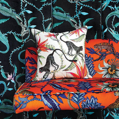 Lifestyle view of the white Monkey Bean Pillow styled on a bright orange tropical pattern bench against a black botanical wallpaper background.