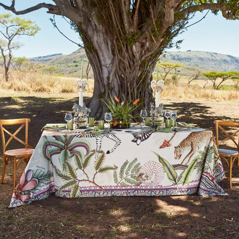 Pangolin Park tablecloth styled on an outdoor dining table beneath a tree with safari-inspired table settings.