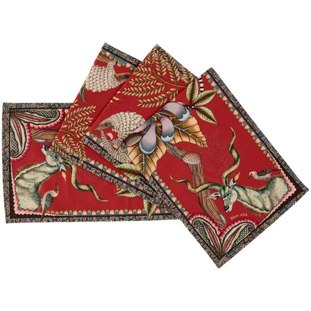 Folded Ardmore table runner showing antelope, a spotted big cat, tropical foliage, flowers, and ornate borders on a red background.