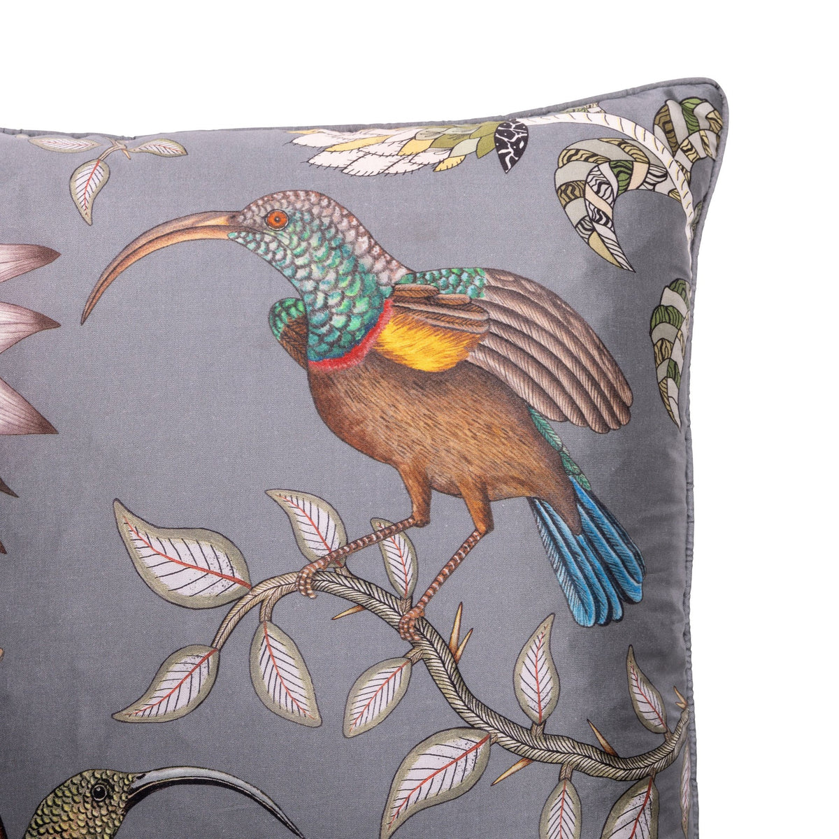 Close-up of the pillow showing a richly detailed bird with turquoise, brown, yellow, and blue plumage perched among pale leaves.