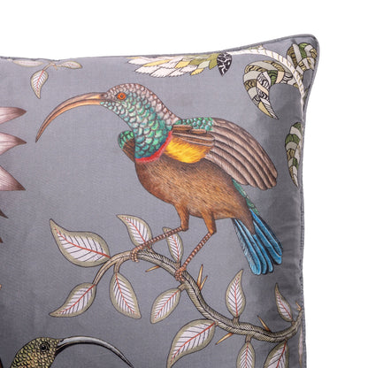 Close-up of the pillow showing a richly detailed bird with turquoise, brown, yellow, and blue plumage perched among pale leaves.