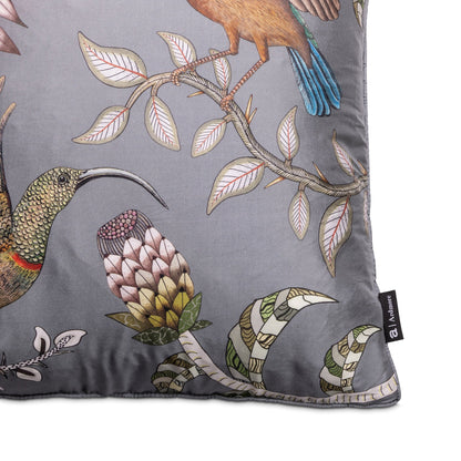 Close-up of the pillow featuring a long-beaked bird, a pink-and-cream protea-like flower, leafy branches, and the Ardmore brand label.