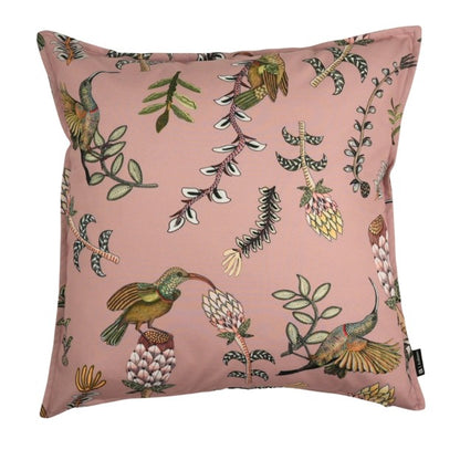 Square blush pink decorative pillow featuring colorful hummingbirds, flowering plants, leafy branches, and scattered botanical illustrations.