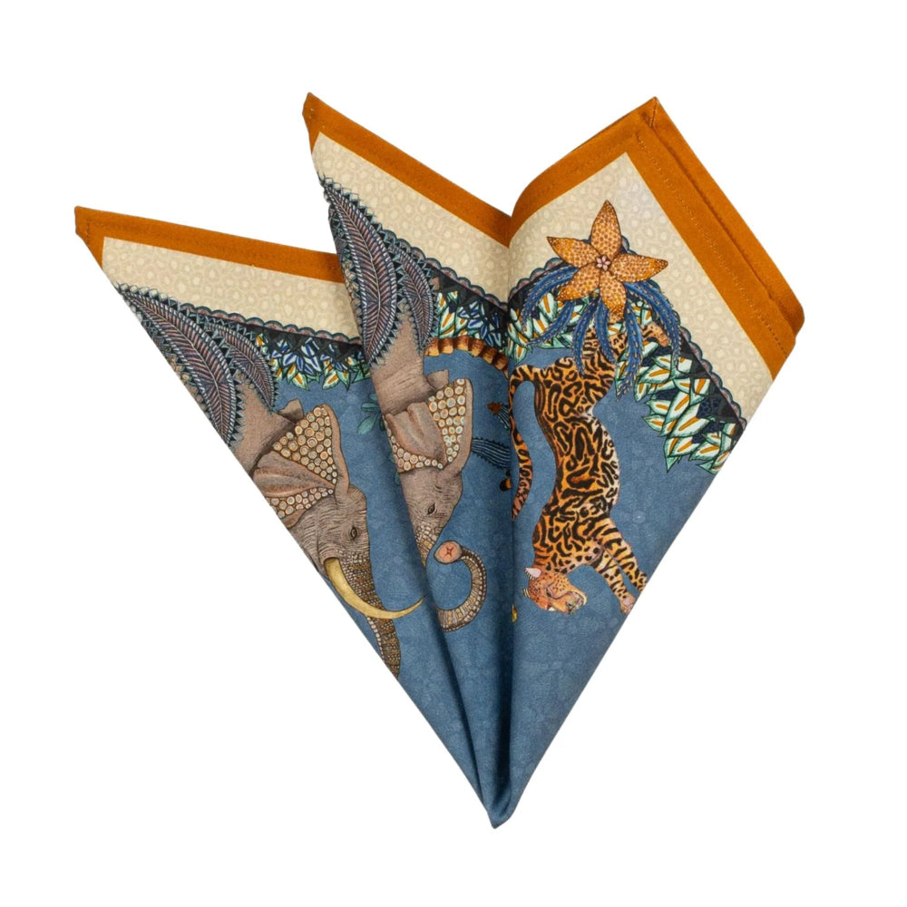 Folded Sabie Forest napkin showing elephant, cheetah, blue background, and orange border.