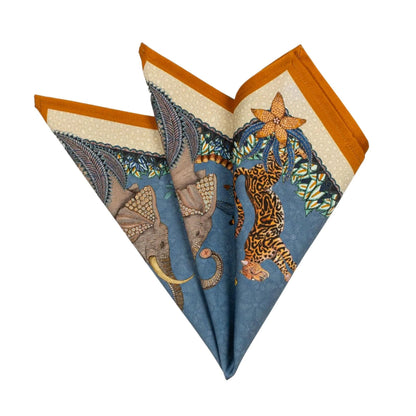Folded Sabie Forest napkin showing elephant, cheetah, blue background, and orange border.