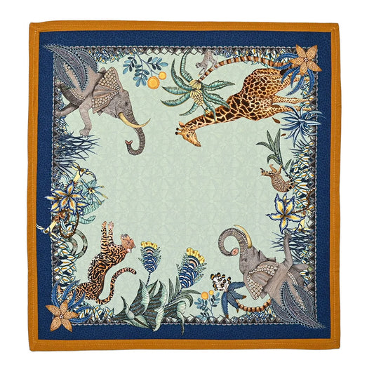 Sabie Forest Napkin featuring a pale aqua center framed in deep navy and warm ochre, with illustrated giraffes, elephants, a tiger, tropical foliage, and floral details.